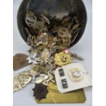Tin containing many cap badges from assorted regiments and dog tags
