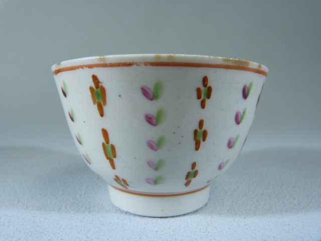 Miniature (unmarked) Sake cup. Decorated in underglaze Ochre, Green and Pink with floral stripes.