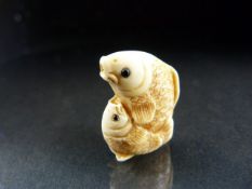 Netsuke: Carved Ivory Netsuke of a mother carp cradling her young carp, signed in Red.