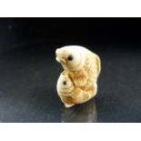 Netsuke: Carved Ivory Netsuke of a mother carp cradling her young carp, signed in Red.