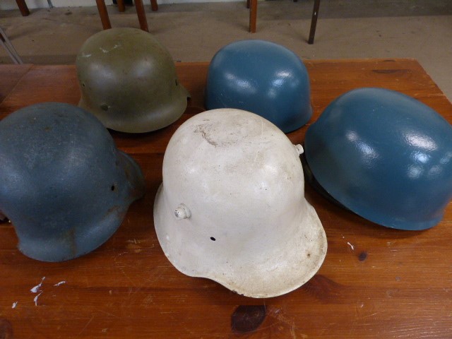 MILITARIA - Three German helmets (1 with shot hole) and two other helmets