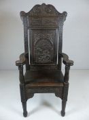 Wainscott Oak antique chair with heavily carved back and arms on block feet.