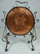 Arts and Crafts copper hammered fire screen decorated with a central flower and two leaves in a