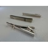 Two hallmarked silver Dunhill money clips along with a Michael Schumacher clip