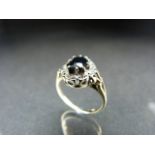 9ct gold ladies ring with dark coloured central stone