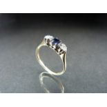 Gold and Platinum ladies ring set with a central square dark sapphire and diamond shoulders
