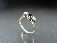 Gold and Platinum ladies ring set with a central square dark sapphire and diamond shoulders