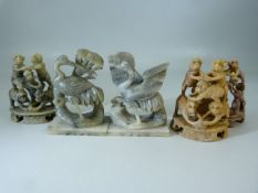 Three carved soapstone monkey figures in pyramids along with a crane soapstone figure.