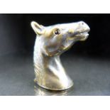 Brass cased vesta in the form of a horse head with red eyes.