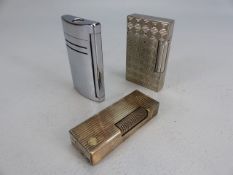 Two silver coloured DUPONT lighters and a dunhill lighter