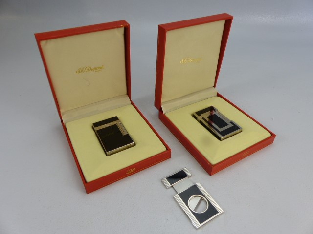 Two boxed DUPONT black and white lighters (Paris) with additional St DUPONT cigar lighter