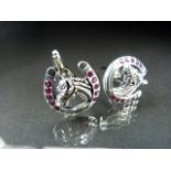 Silver and ruby set cufflinks in the form of horse shoes set with a horses head