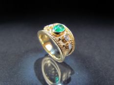 18CT yellow gold Cartier-style wide banded ring with central emerald flanked by diamonds