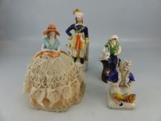 Three late 19th century staffordshire figures, and porcelain topped pin cushion in the form of a