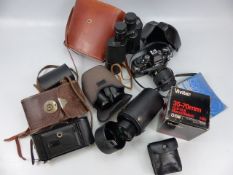 An Olympus OM10 35mm camera and a selection of lenses and binoculars