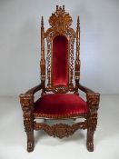 Heavily carved and red upholstered Throne Chair. The arms carved with lions heads. approx 180cm high