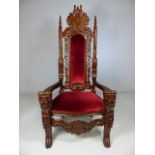 Heavily carved and red upholstered Throne Chair. The arms carved with lions heads. approx 180cm high