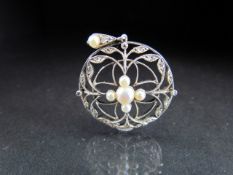 Delicate Silver coloured circular brooch with seed pearls and leaves set with small diamonds