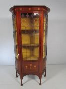 Arts and Crafts display cabinet with shaped front and sides. The top frieze panel inlaid with copper