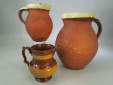 Three terracotta slipware jugs