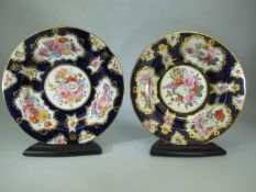 Two late 19th century Cabinet plates with blue and gold floral patterns and stands.