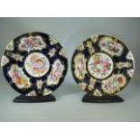 Two late 19th century Cabinet plates with blue and gold floral patterns and stands.