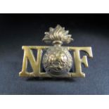 Northumberland Fusiliers insignia with Flaming Grenade and St George and the Dragon inscribed "Quo