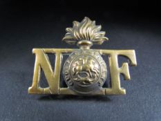 Northumberland Fusiliers insignia with Flaming Grenade and St George and the Dragon inscribed "Quo