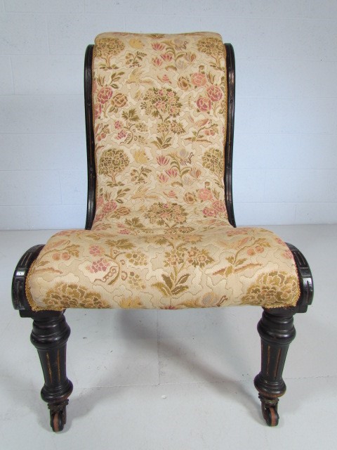 Antique ebonised nursing chair with floral upholstery