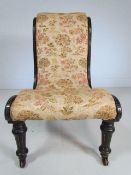 Antique ebonised nursing chair with floral upholstery