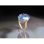 14ct Gold dress ring set with large oval blue stone.