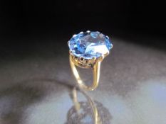 14ct Gold dress ring set with large oval blue stone.