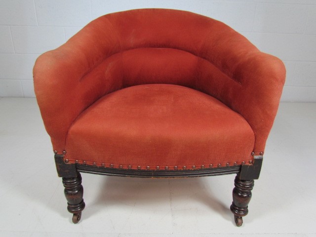 Small antique tub chair in red upholstery on turned wooden legs