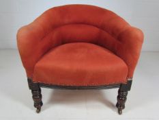 Small antique tub chair in red upholstery on turned wooden legs