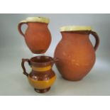 Three terracotta slipware jugs