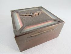 Square metal cigarette box bearing the RAF eagle emblem and four clear panels displaying the RAF