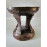 Hand carved tribal/African headrest on base with four supports and green hue to the upper surface