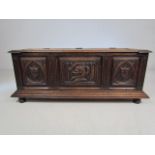 Oak Coffer with carved decoration to front standing on Bun feet