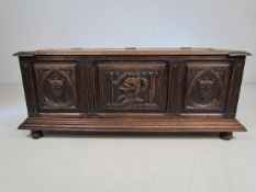 Oak Coffer with carved decoration to front standing on Bun feet