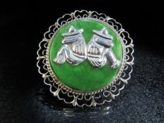 Designer brooch in silver with filigree work ring and set with a large flat green stone, mounted