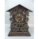 Large Black Forrest Cuckoo clock with ornate carving and view windows to both sides with bellows for
