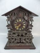 Large Black Forrest Cuckoo clock with ornate carving and view windows to both sides with bellows for