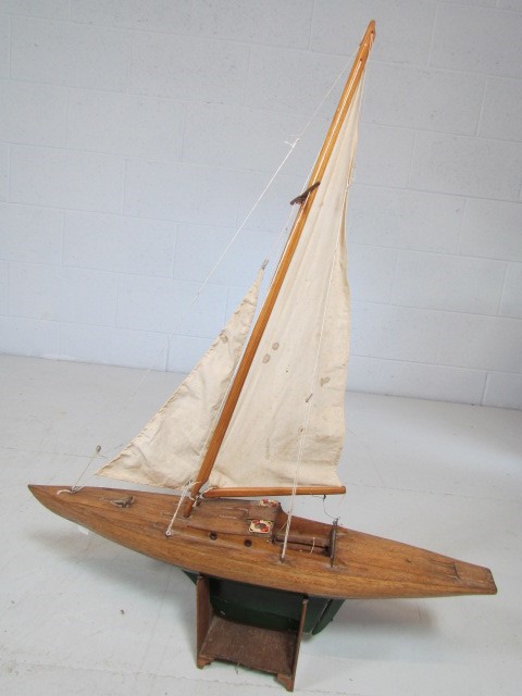 Handmade wooden racing boat with sails on stand