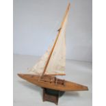Handmade wooden racing boat with sails on stand