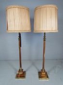 Two 1960's wooden and brass standard lamps with shades.