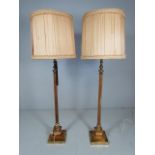 Two 1960's wooden and brass standard lamps with shades.