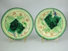 Two Majolica leaf plates decorated with flowers and blue ribbons
