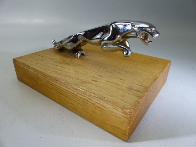 Chrome Jaguar car mascot on wooden stand
