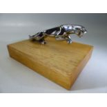 Chrome Jaguar car mascot on wooden stand