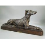 French figure of a recumbent dog by Floro. 'Chien Levrier, Per Floro'.